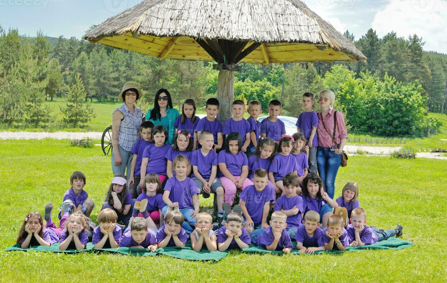 groep gelukkige kinderen met leraar in de natuur foto