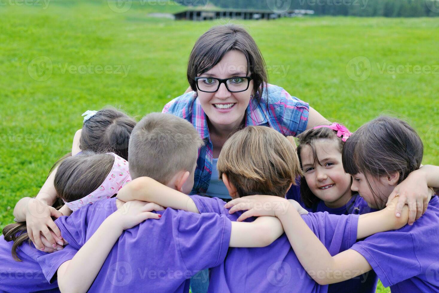 groep gelukkige kinderen met leraar in de natuur foto