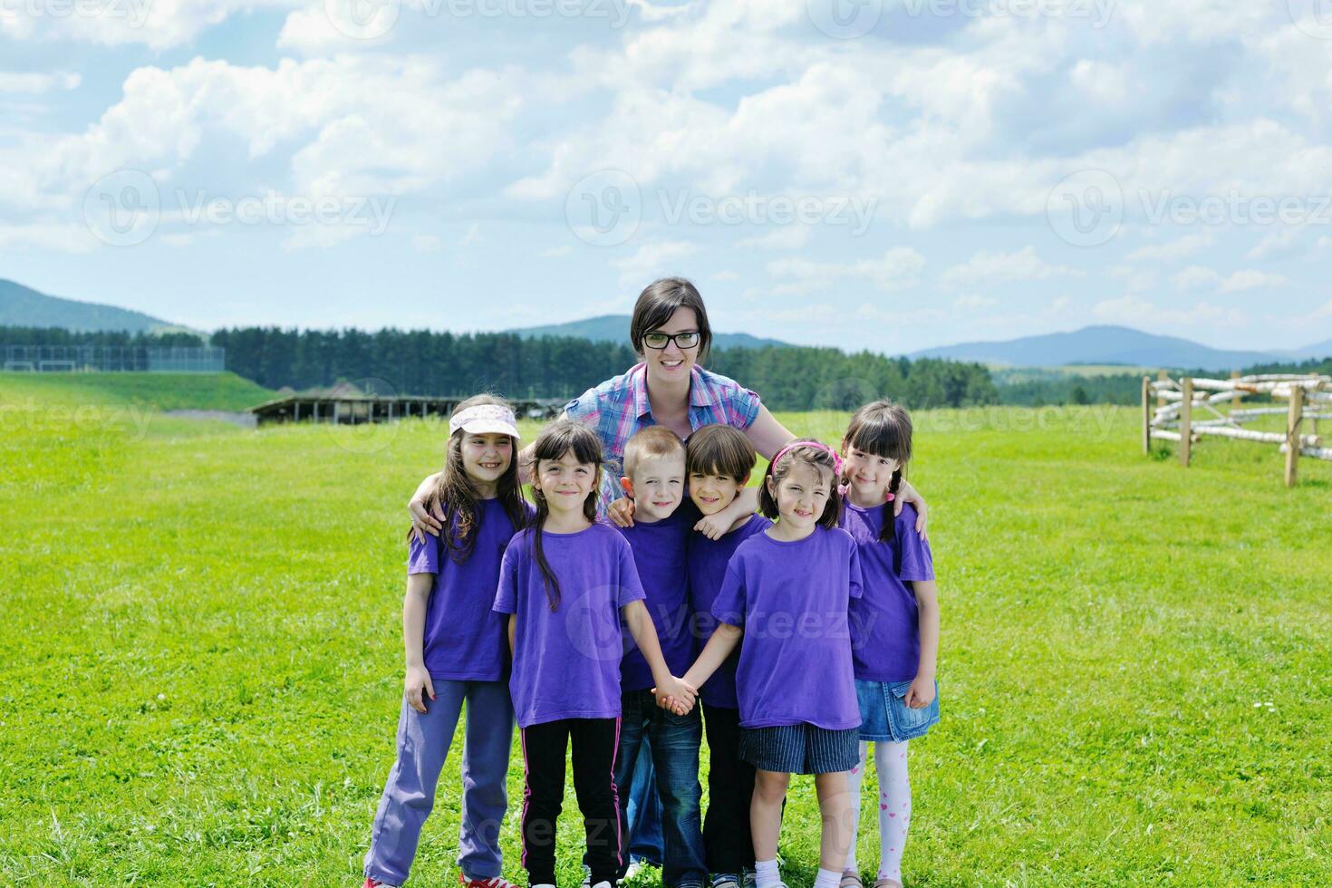 groep gelukkige kinderen met leraar in de natuur foto