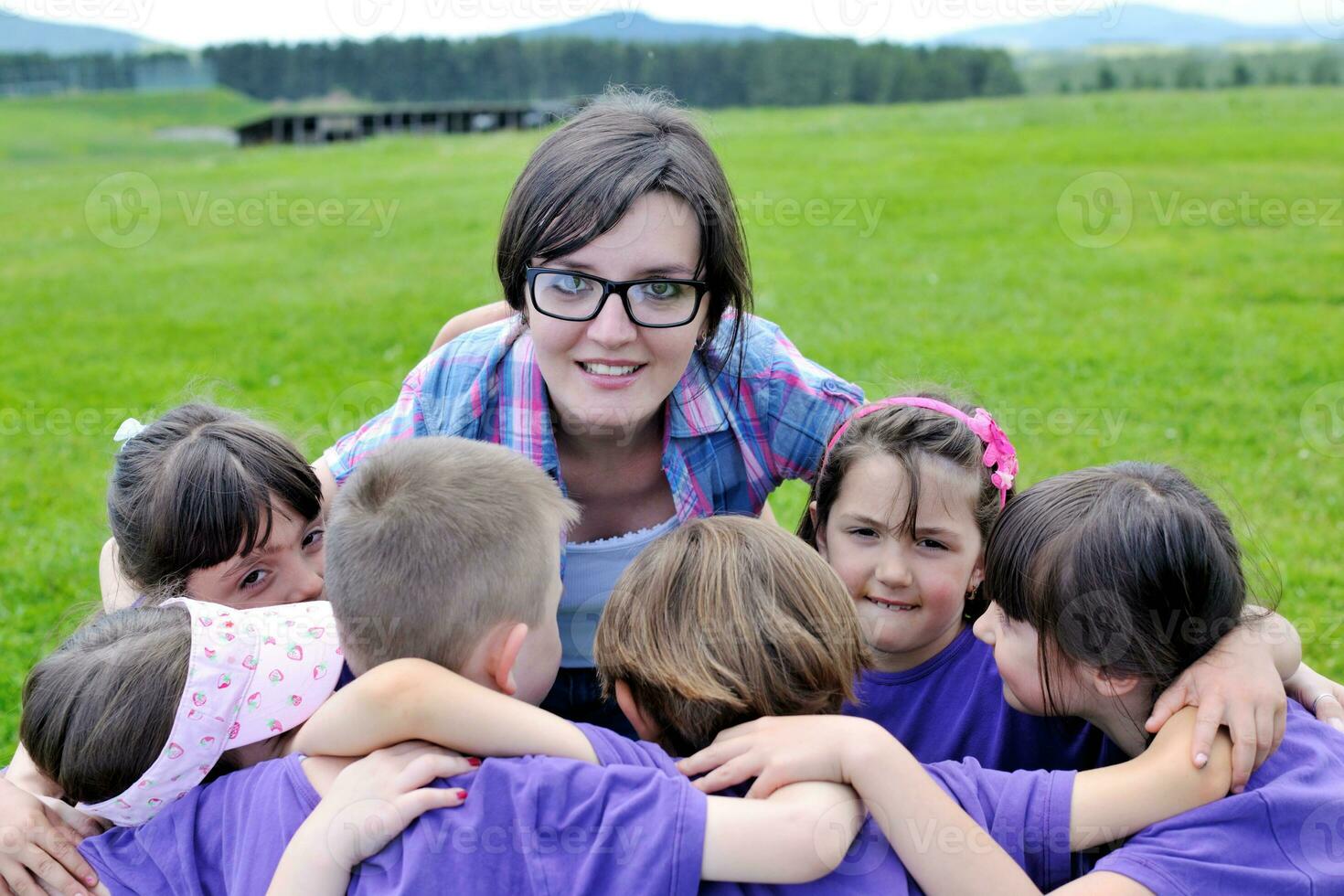 groep gelukkige kinderen met leraar in de natuur foto