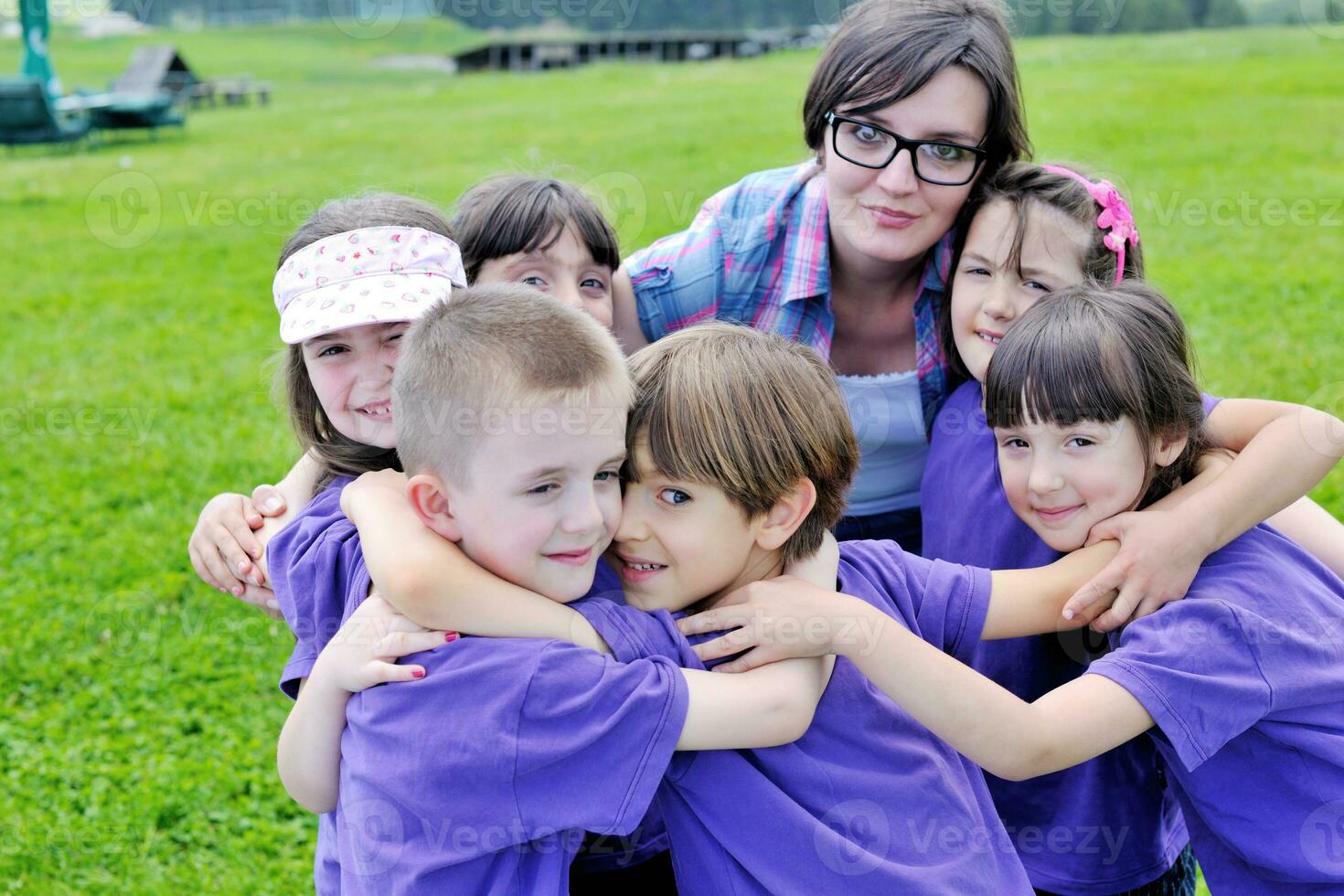 groep gelukkige kinderen met leraar in de natuur foto