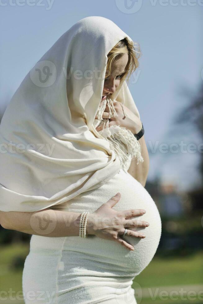 gelukkig jong zwanger vrouw buitenshuis foto