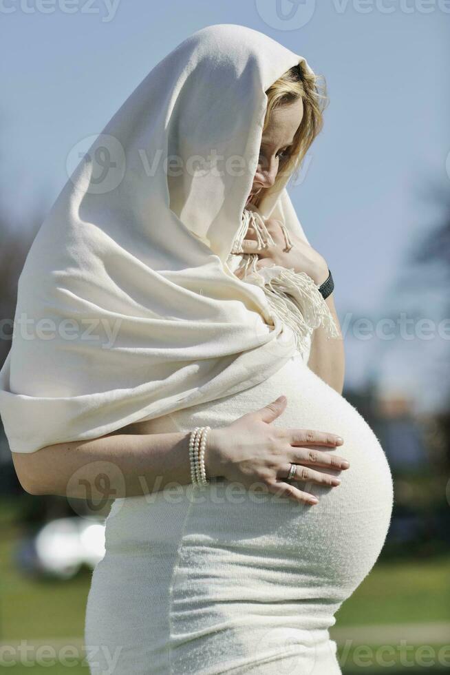 gelukkig jong zwanger vrouw buitenshuis foto