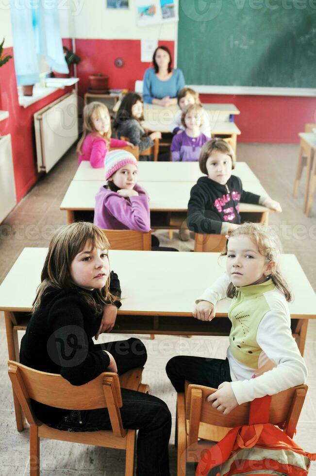gelukkig kinderen met leraar in school- klas foto