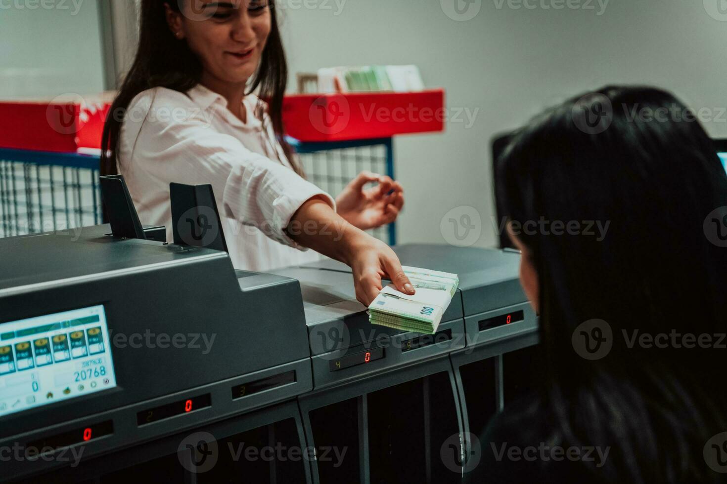 bank medewerkers gebruik makend van geld tellen machine terwijl sorteren en tellen papier bankbiljetten binnen bank kluis. groot bedragen van geld in de bank foto