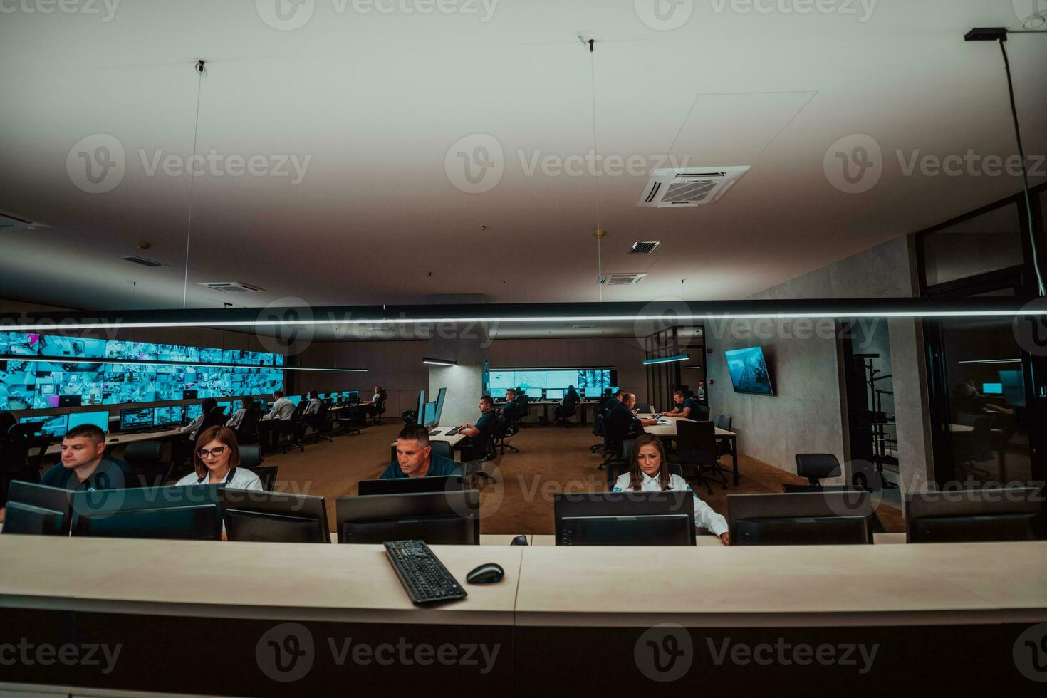 groep van veiligheid gegevens centrum operators werken in een cctv toezicht houden kamer op zoek Aan meerdere monitoren officieren toezicht houden meerdere schermen voor verdacht activiteiten team werken Aan de systeem controle foto