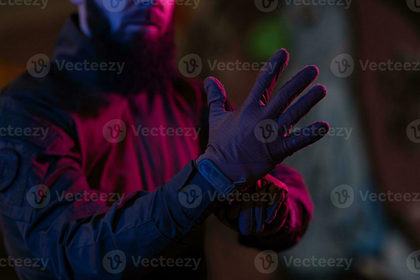 foto van een ten volle uitgerust soldaat in zwart schild tactisch hesje en handschoenen staand Aan zwart achtergrond detailopname voorkant visie.