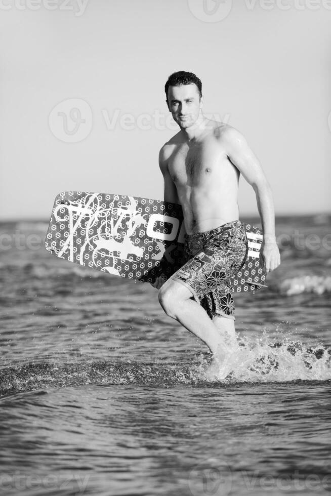 portret van een jong kitsurfen Mens Bij strand Aan zonsondergang foto