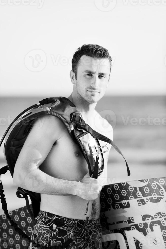 portret van een jong kitsurfen Mens Bij strand Aan zonsondergang foto