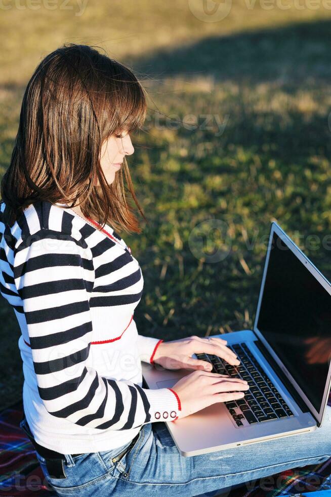 jong tienermeisje werkt op laptop buiten foto