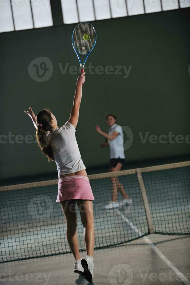 jong meisjes spelen tennis spel binnen- foto