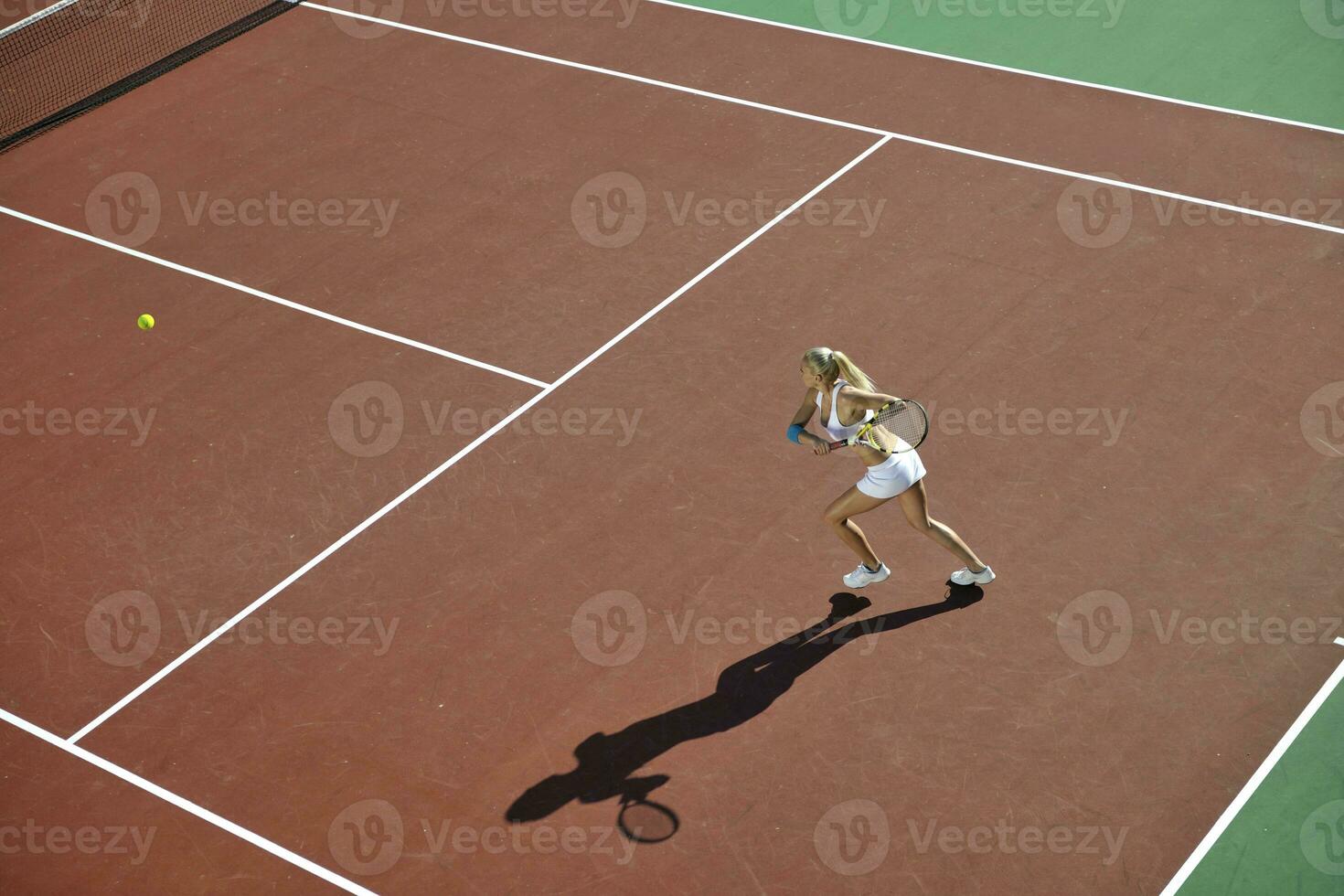 jonge vrouw tennissen buiten foto