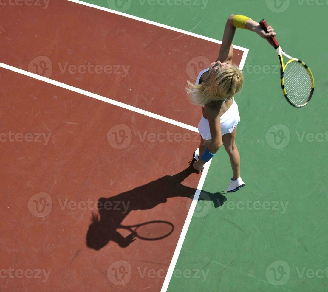 jonge vrouw speelt tennisspel buiten foto