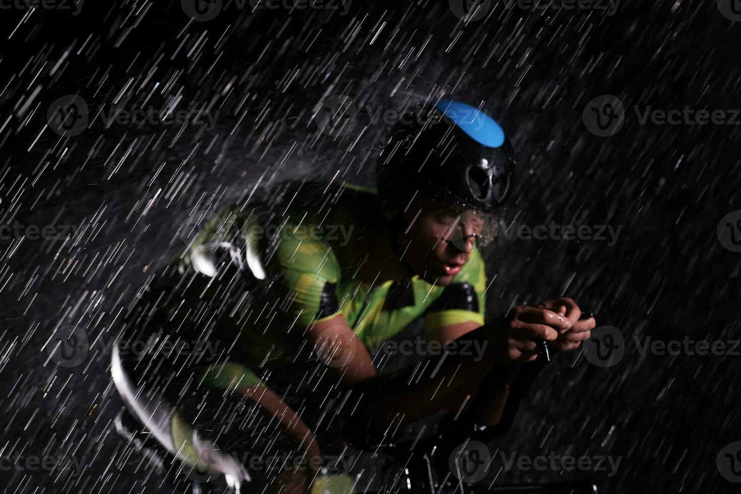 triatlon atleet rijden fiets snel Aan regenachtig nacht foto