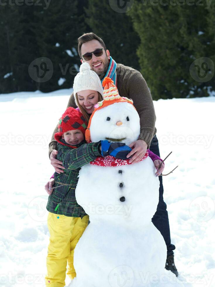 gelukkige familie sneeuwpop maken foto