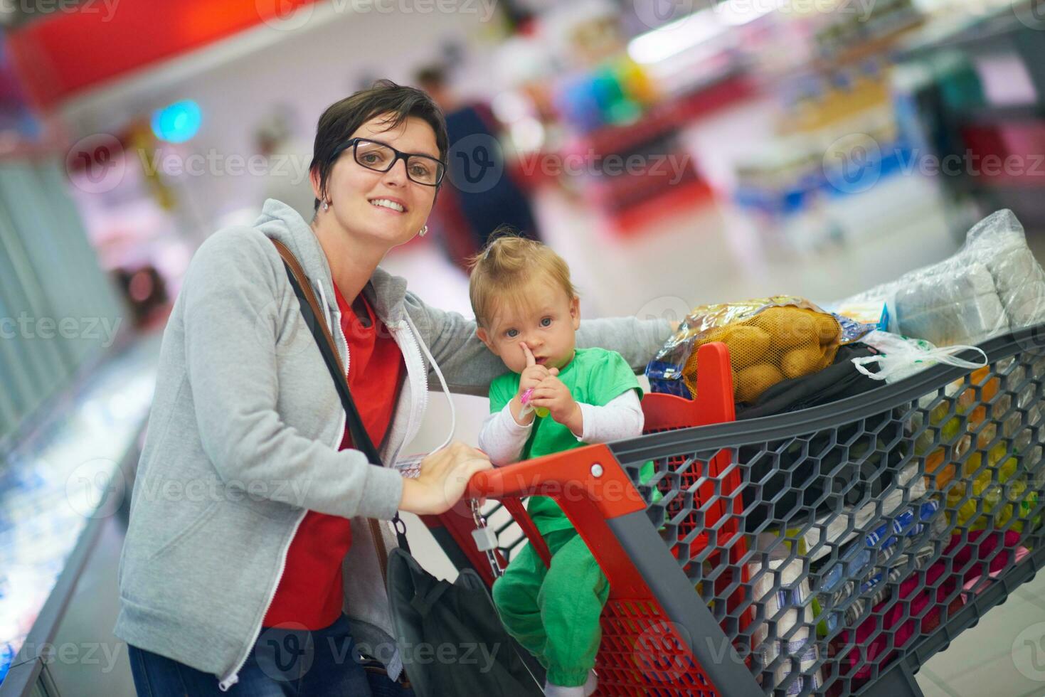 moeder met baby in boodschappen doen foto