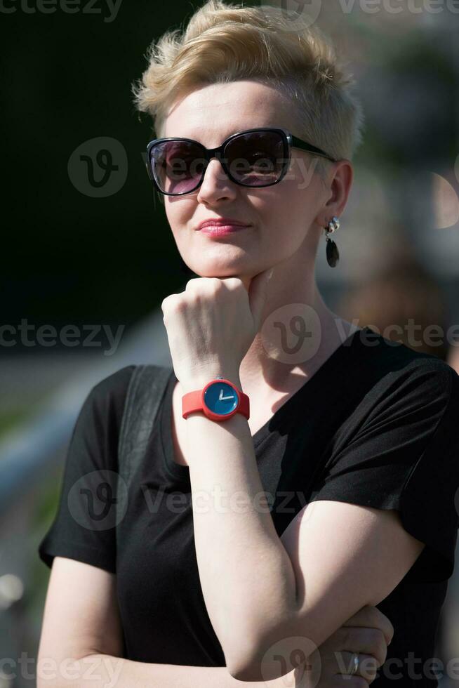 jong vrouw met kort blond haar- en zonnebril foto