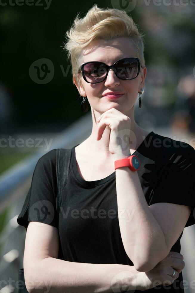 jong vrouw met kort blond haar- en zonnebril foto