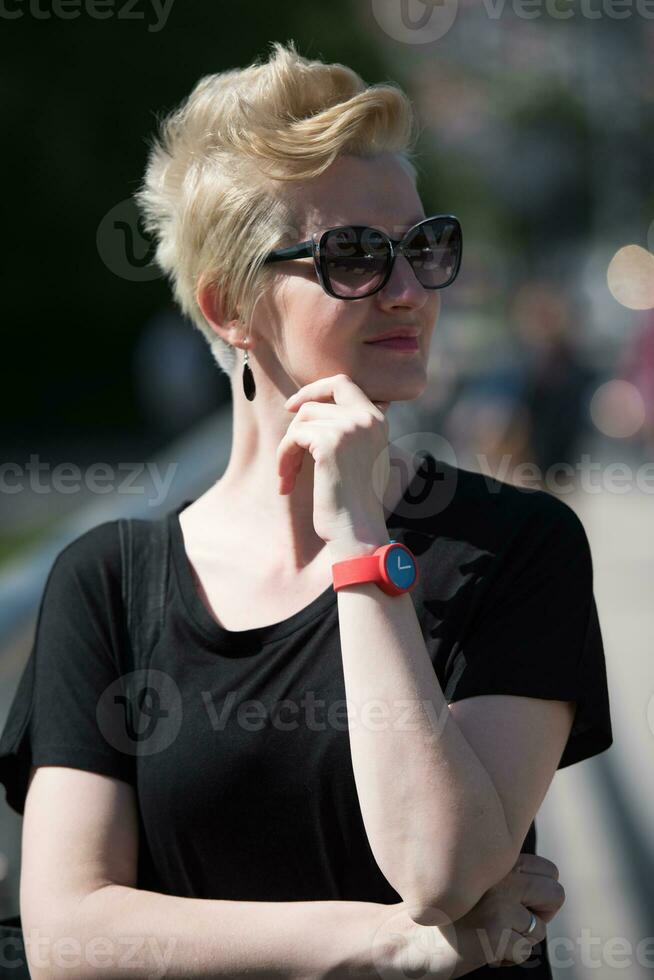 jong vrouw met kort blond haar- en zonnebril foto