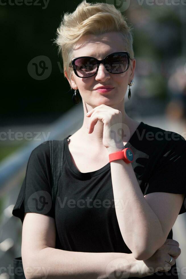 jong vrouw met kort blond haar- en zonnebril foto