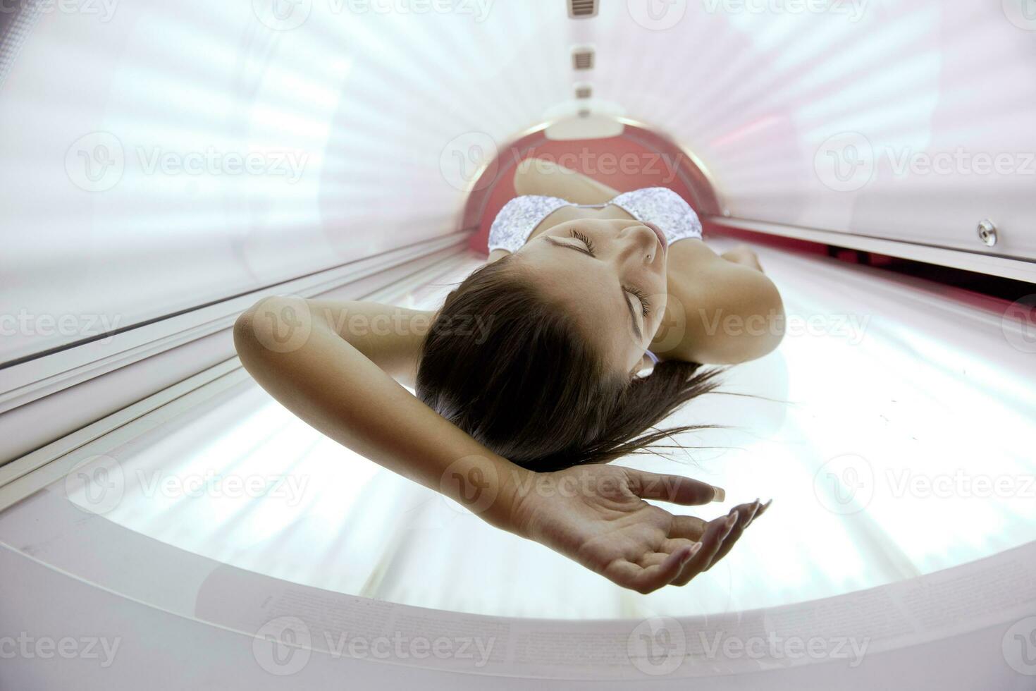 mooi jong vrouw bruinen in solarium foto