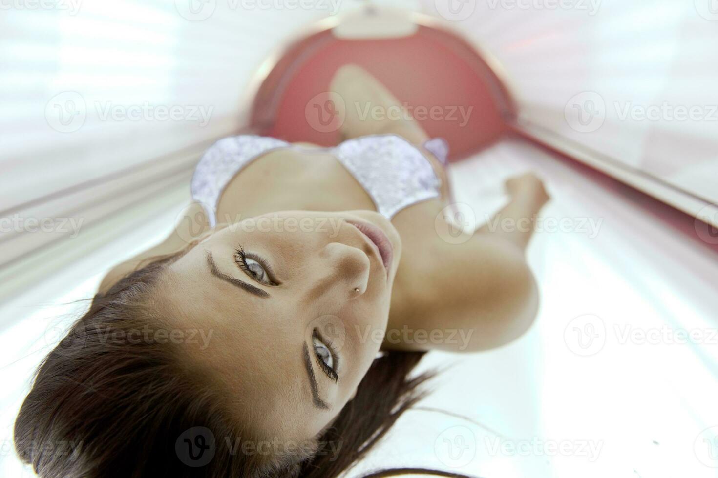 mooi jong vrouw bruinen in solarium foto