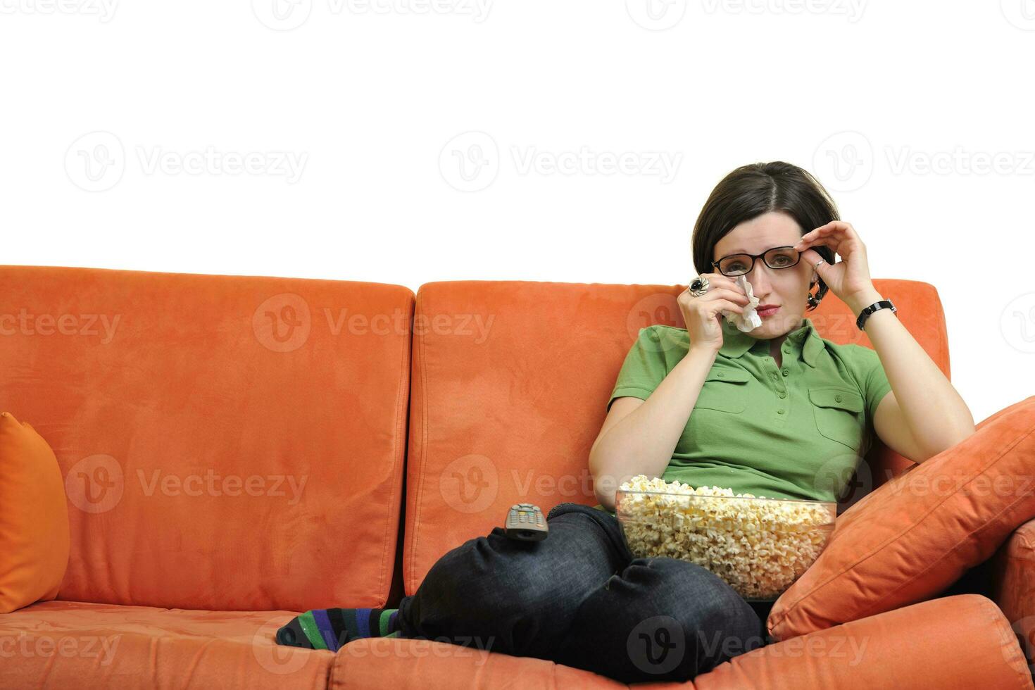 jong vrouw eten popcorn en aan het kijken TV foto