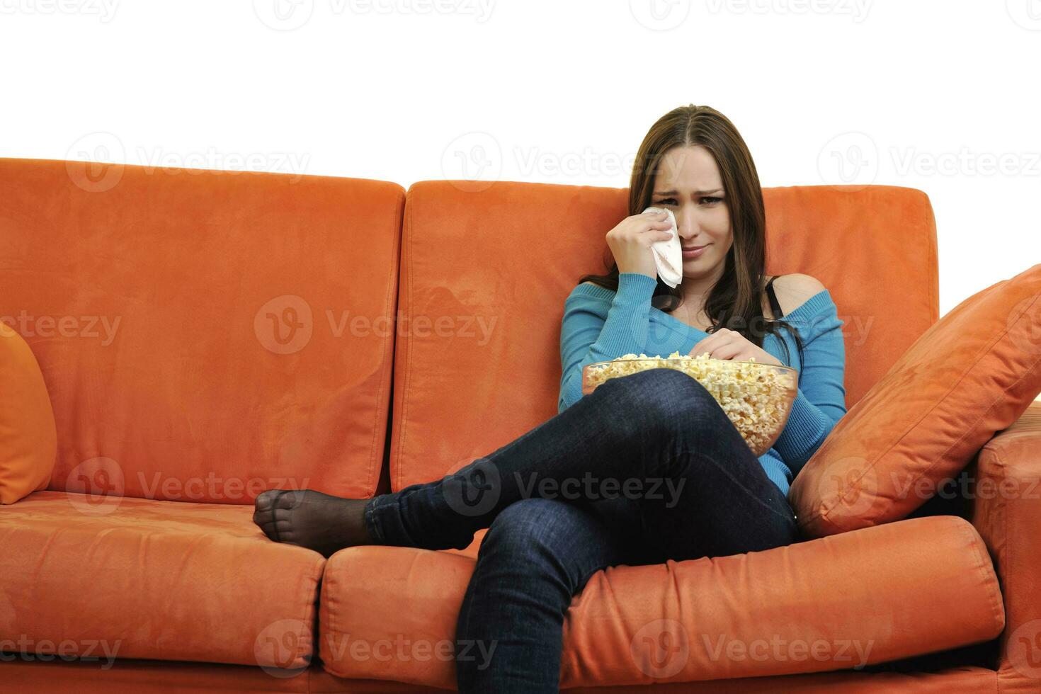 jong vrouw eten popcorn en aan het kijken TV foto