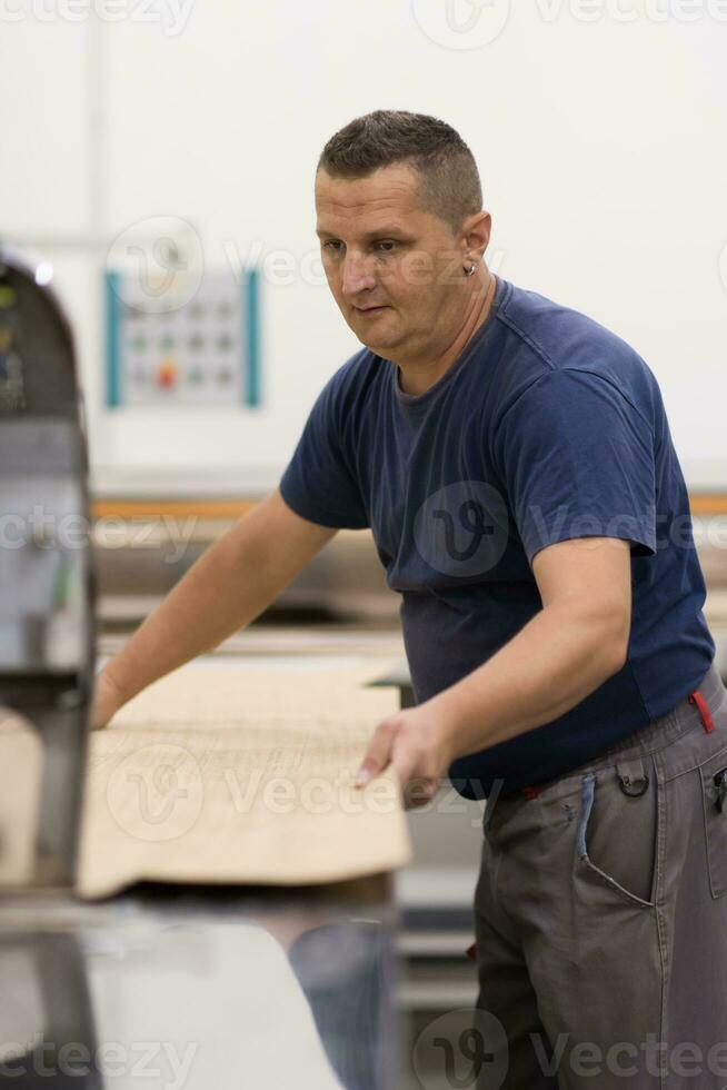 arbeider in een fabriek van houten meubelen foto