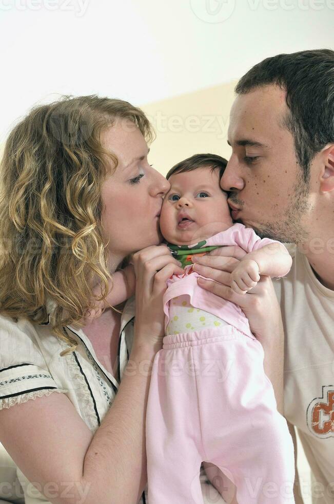 binnen- portret met gelukkig jong familie en schattig weinig schatje foto