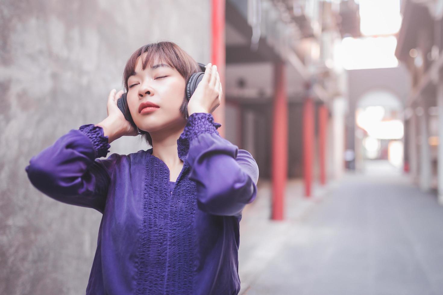 gelukkige jonge aziatische vrouw die naar muziek luistert foto