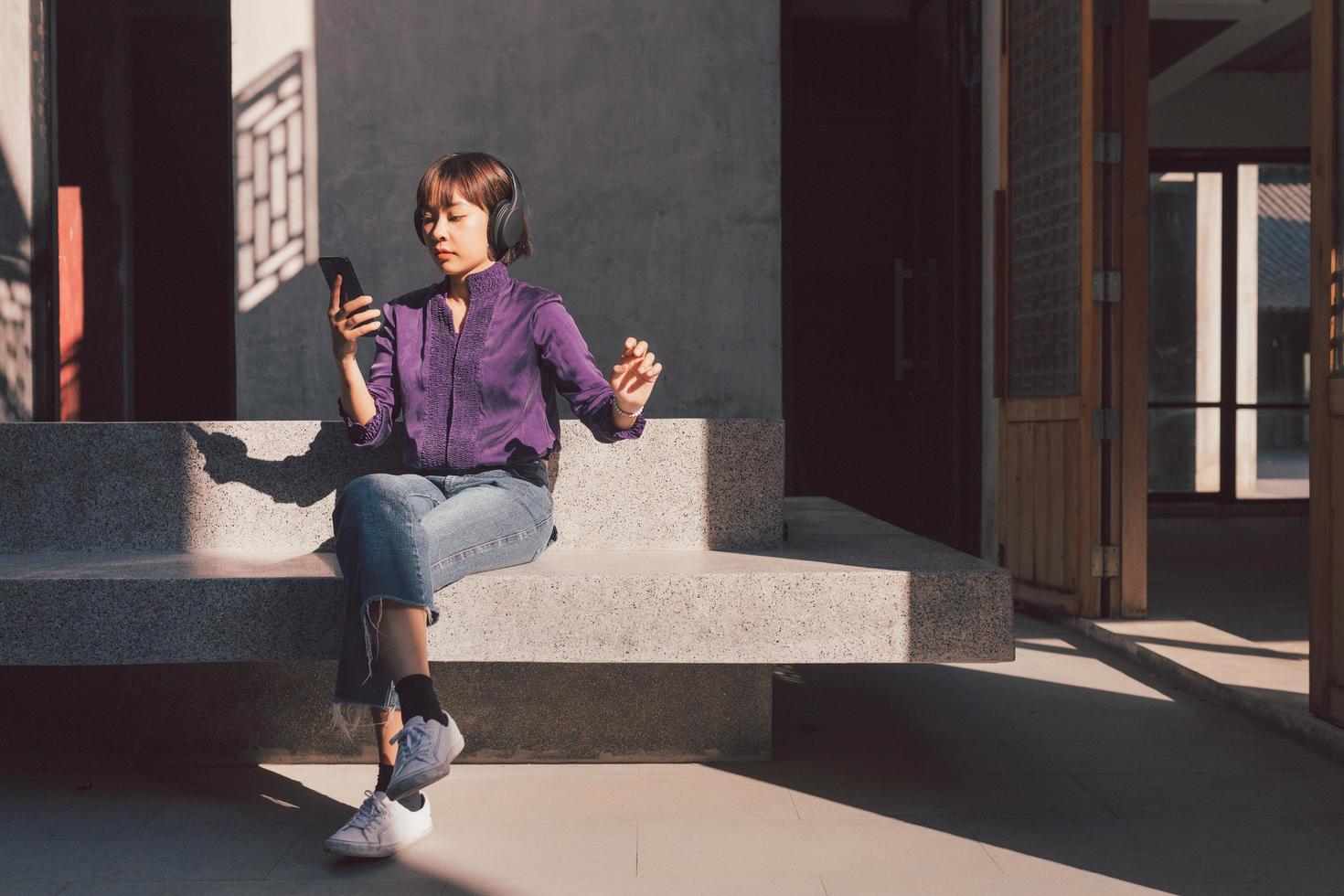 gelukkige jonge aziatische vrouw die naar muziek luistert met een koptelefoon foto