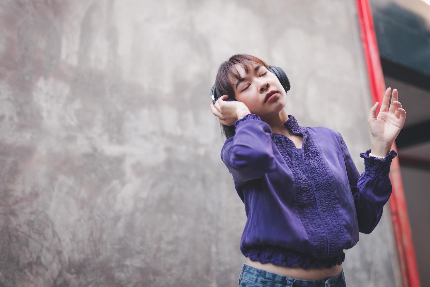 gelukkige jonge aziatische vrouw die naar muziek luistert met een koptelefoon foto