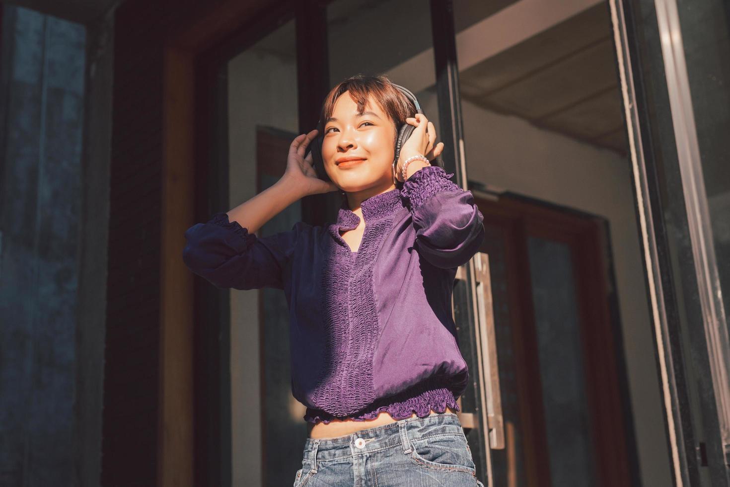 gelukkige jonge aziatische vrouw die naar muziek luistert met een koptelefoon foto