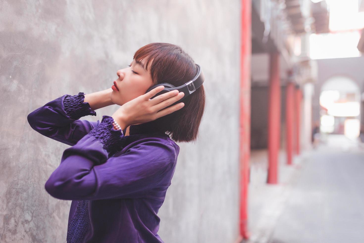 gelukkige jonge aziatische vrouw die naar muziek luistert met een koptelefoon foto