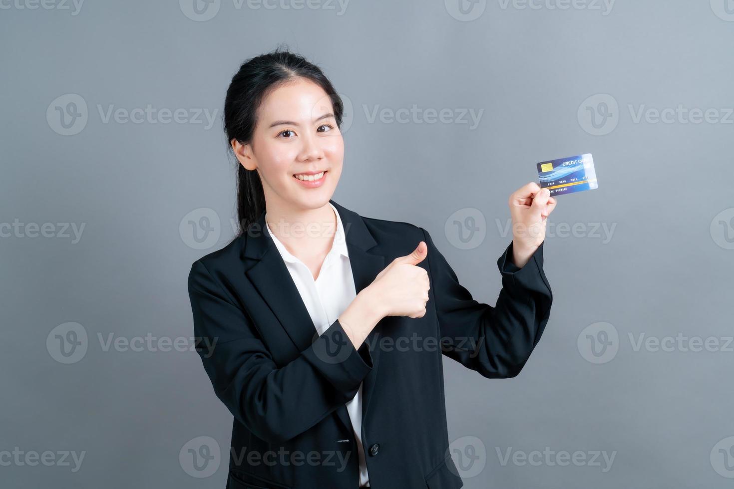 portret van een mooie jonge Aziatische vrouw die creditcard toont foto