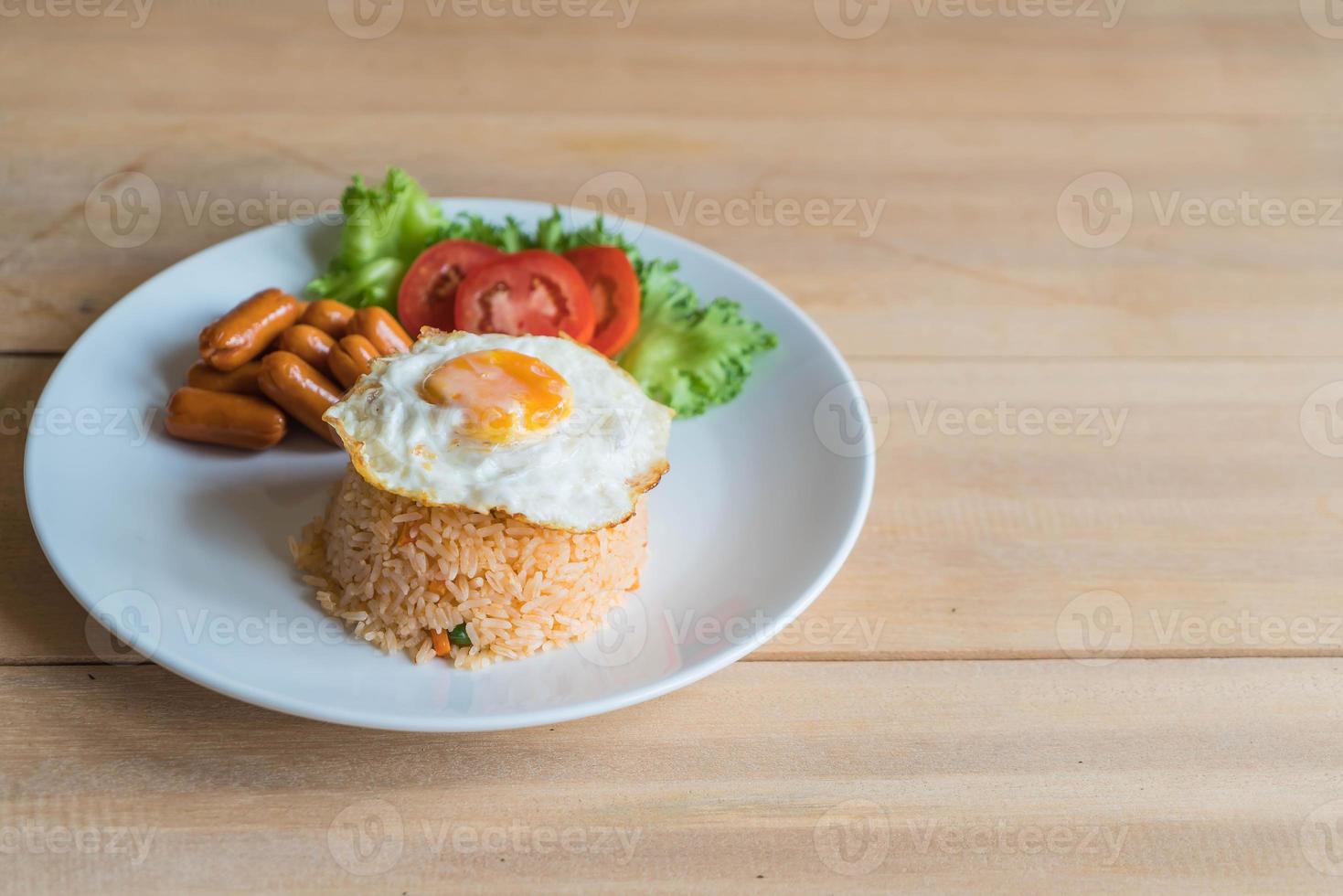 gebakken rijst met worst en gebakken ei op tafel foto