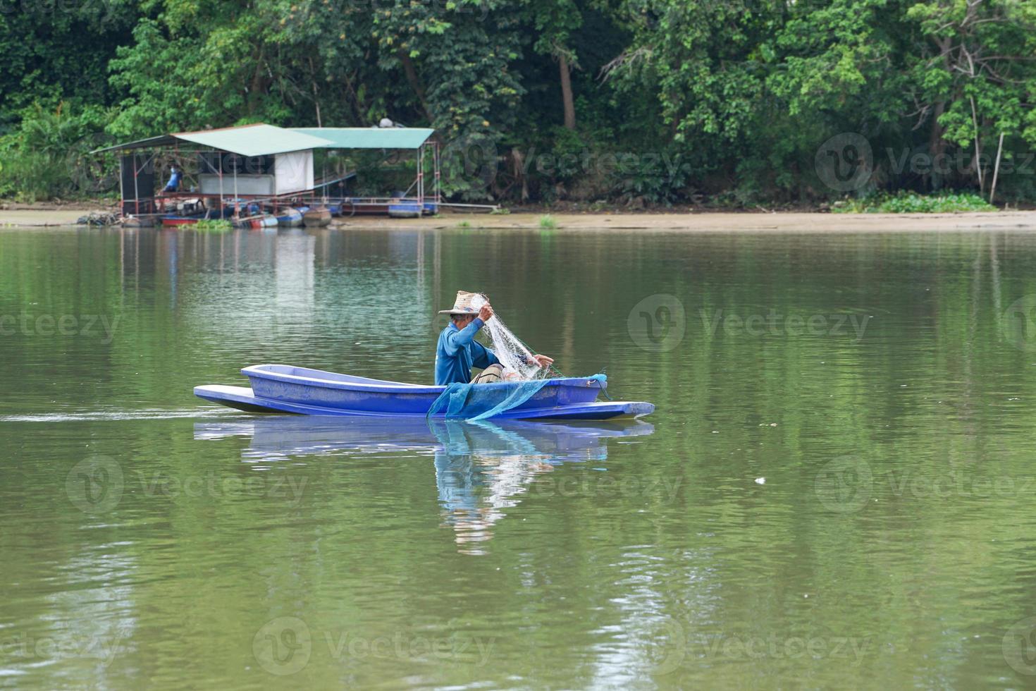 eenzame man zit in de boot en haalt de vis uit het net foto