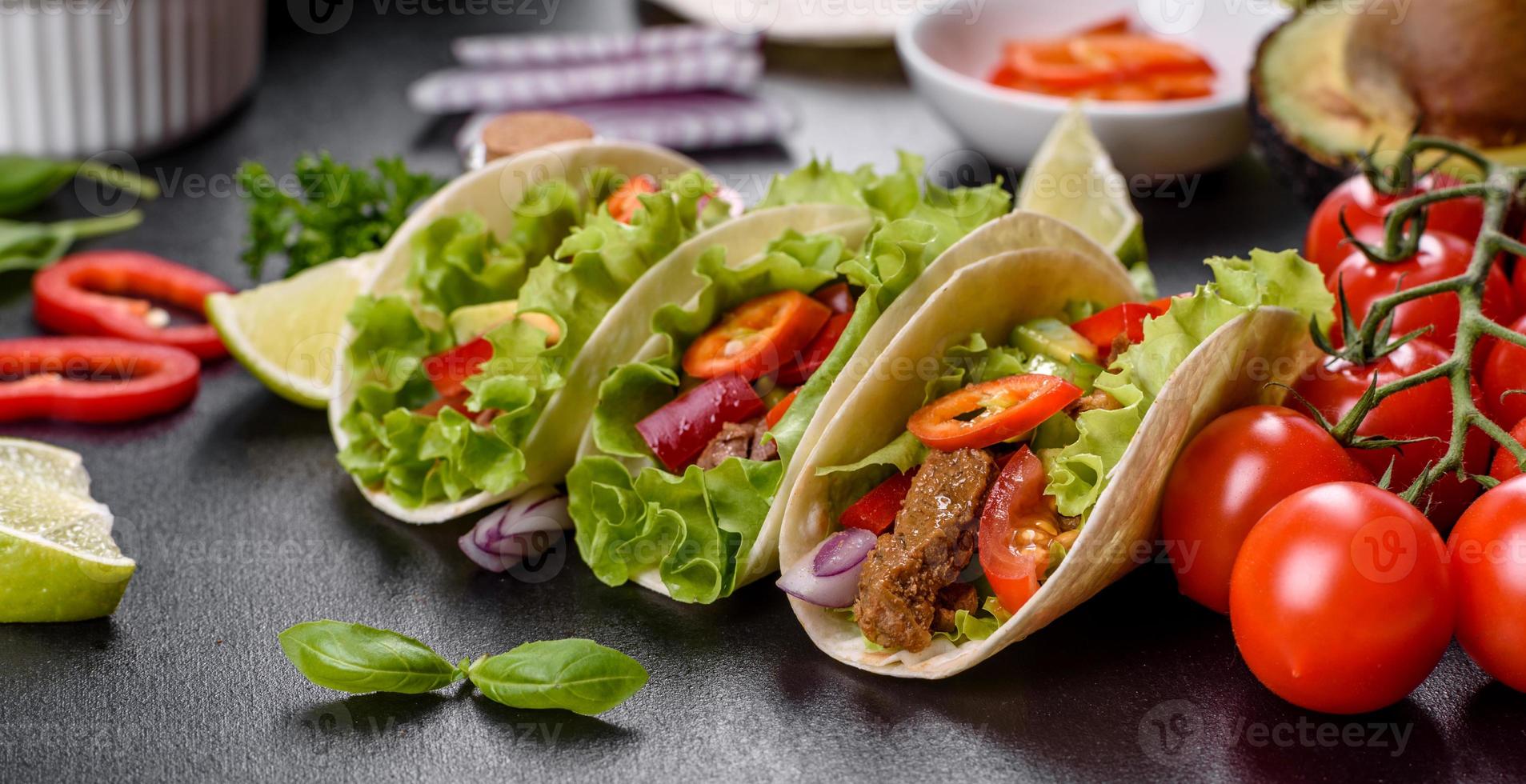 Mexicaanse taco's met rundvlees, tomaten, avocado, ui en salsasaus foto