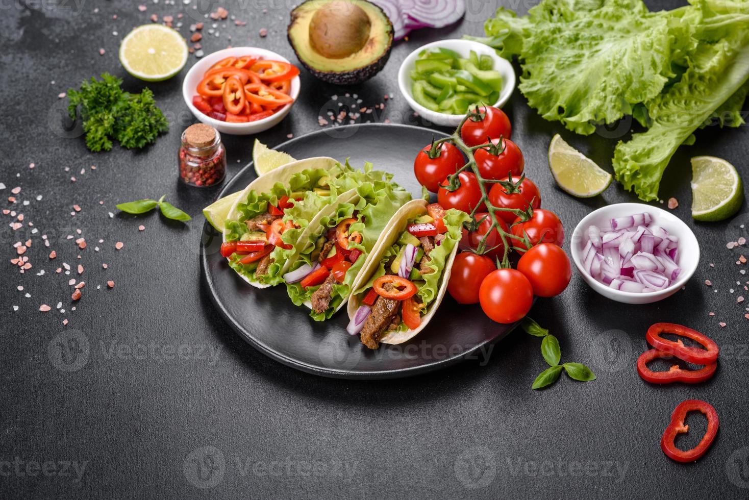 Mexicaanse taco's met rundvlees, tomaten, avocado, ui en salsasaus foto