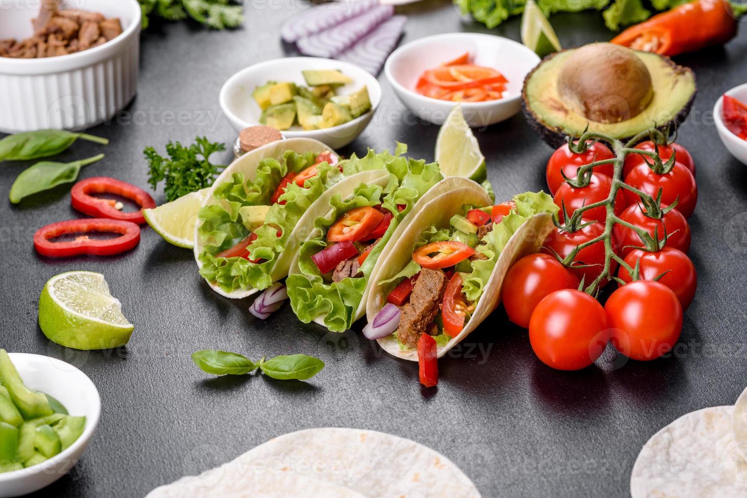 Mexicaanse taco's met rundvlees, tomaten, avocado, ui en salsasaus foto