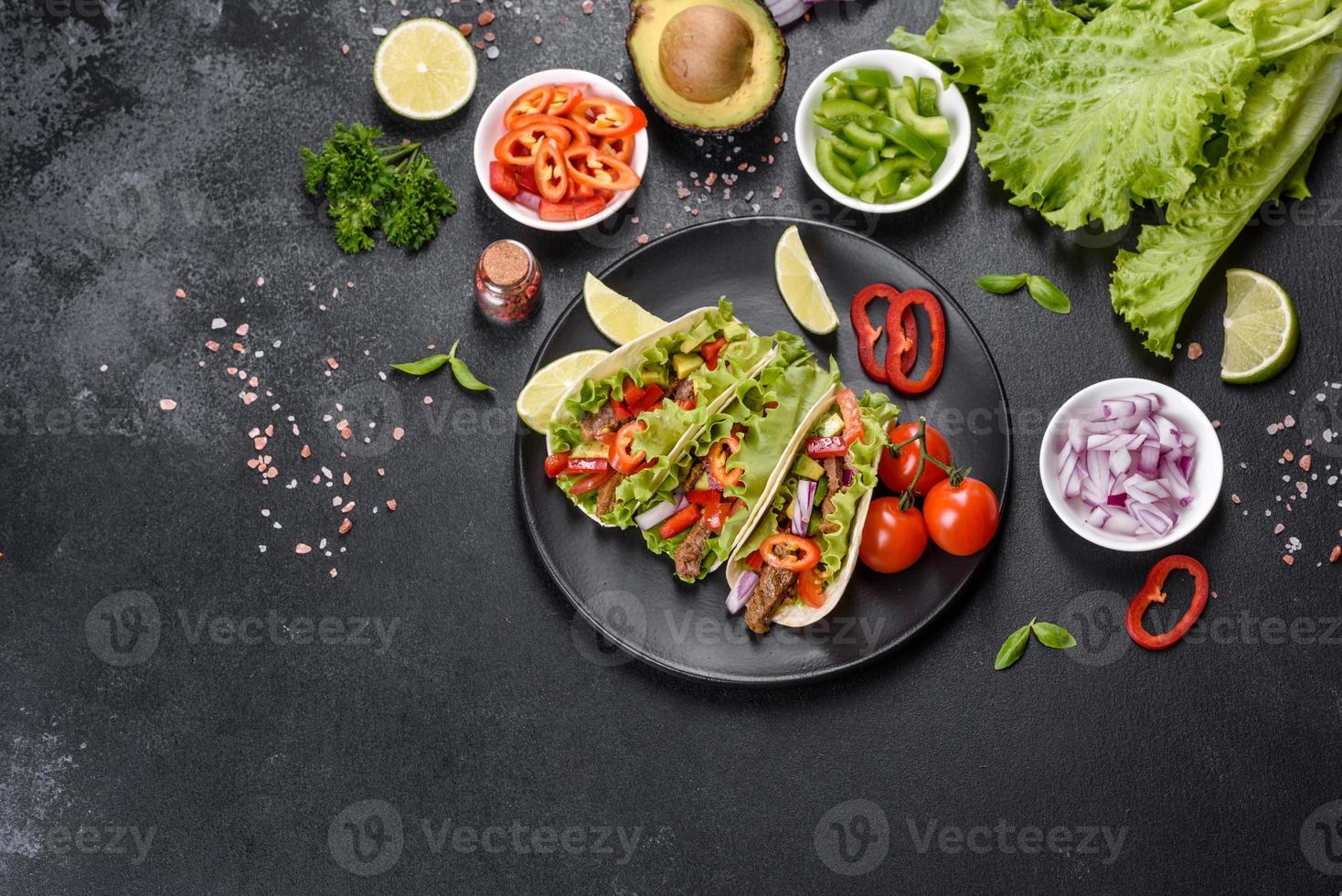 Mexicaanse taco's met rundvlees, tomaten, avocado, ui en salsasaus foto
