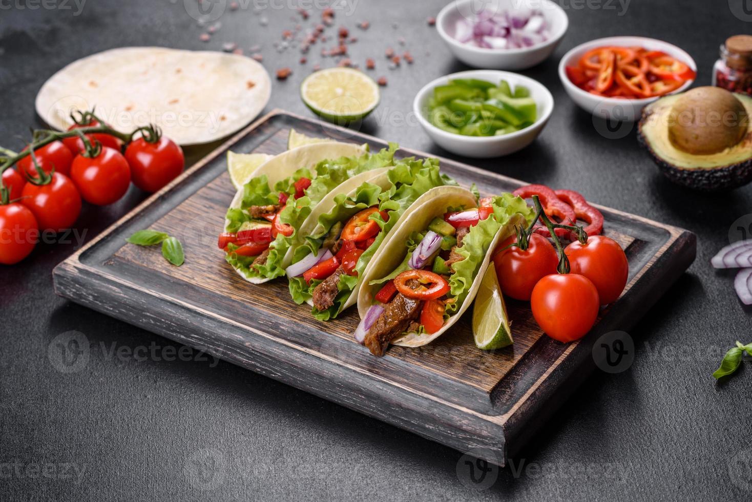 Mexicaanse taco's met rundvlees, tomaten, avocado, ui en salsasaus foto