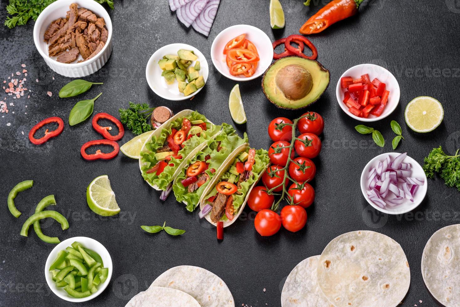 Mexicaanse taco's met rundvlees, tomaten, avocado, ui en salsasaus foto