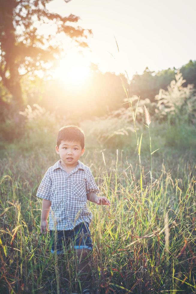 gelukkige kleine Aziatische jongen die buiten speelt. schattig Aziatisch. jongen op het veld. foto