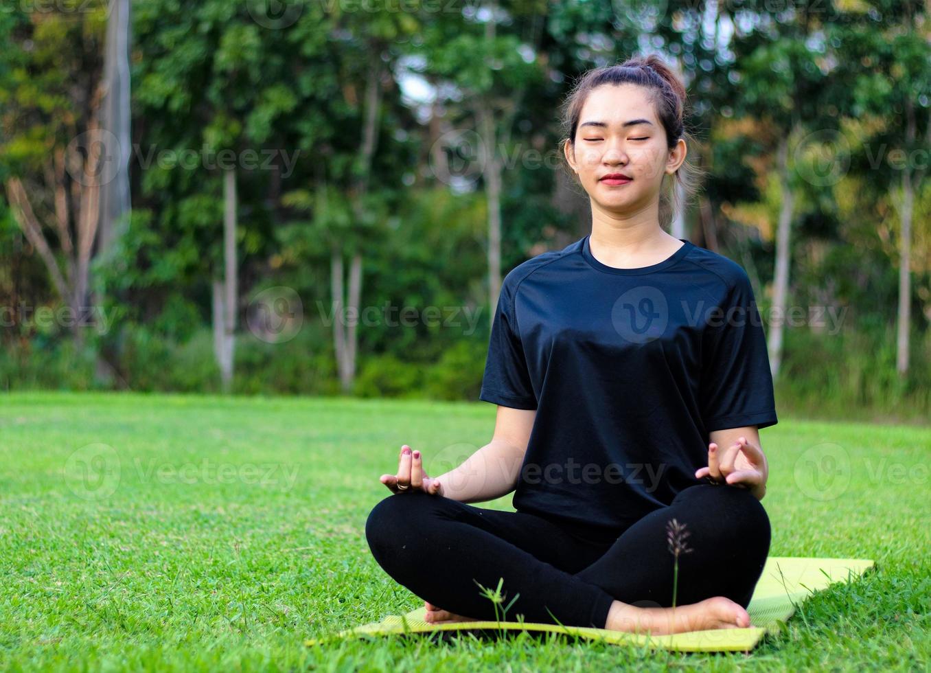 vrouw die mediteert en yoga beoefent in het bos foto