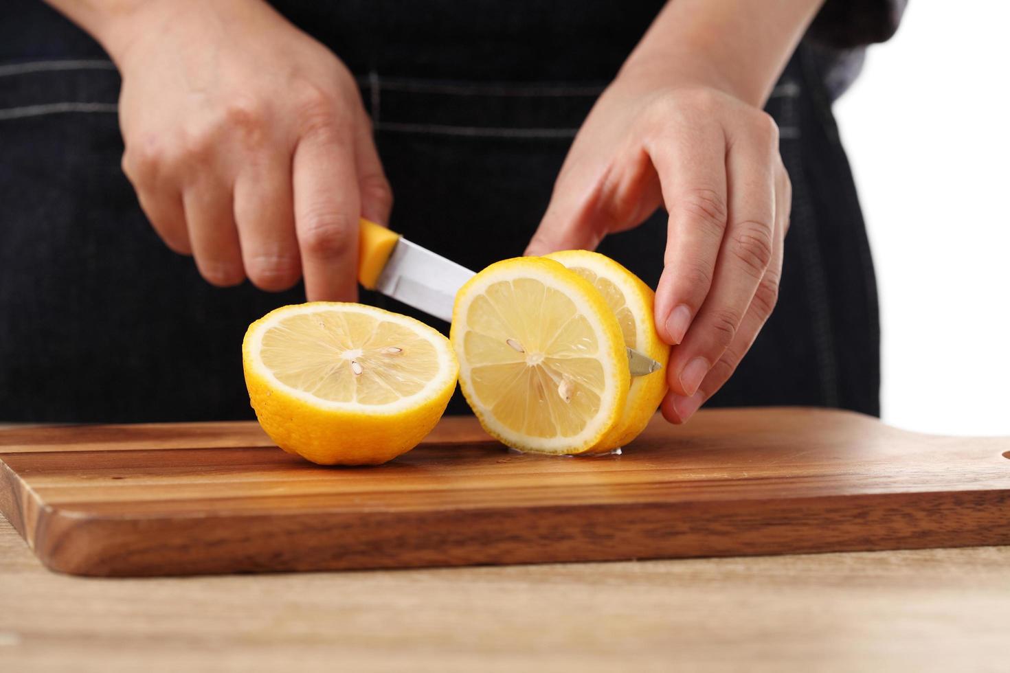 chef-kok snijden citroen met mes voor limonade foto