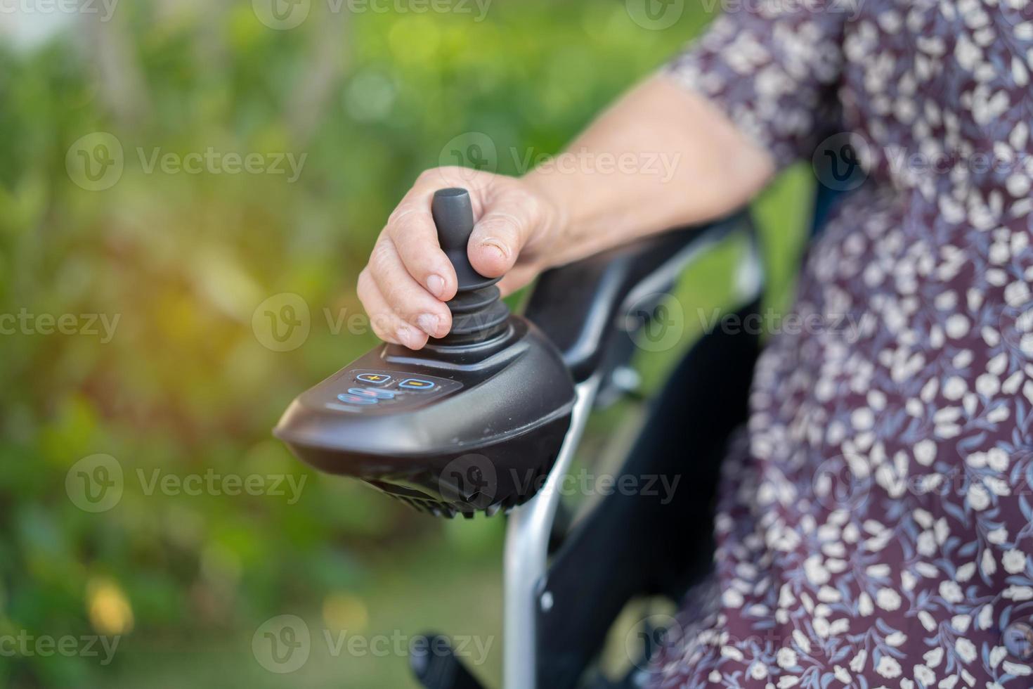Aziatische senior vrouw patiënt op elektrische rolstoel foto