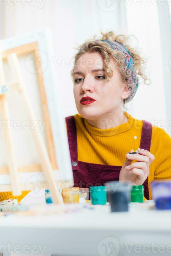 mooi vrouw artiest verven Aan canvas Bij huis foto