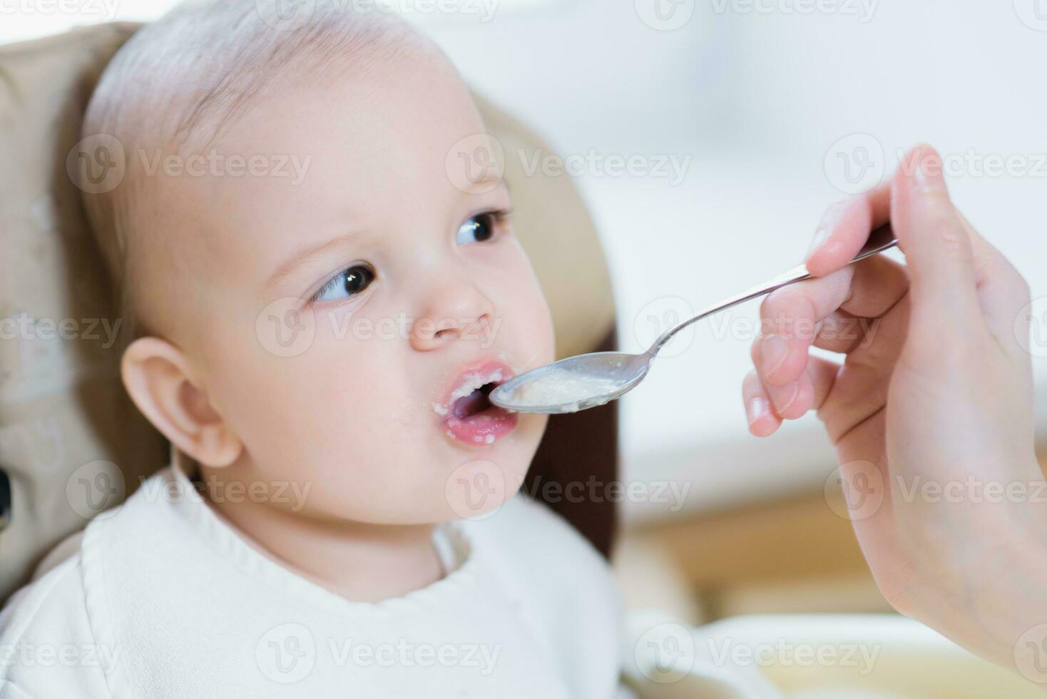 mam feeds haar negen maanden baby Bij huis foto